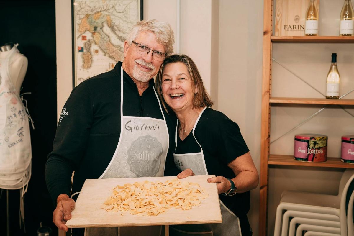a man and a woman holding a box of pasta