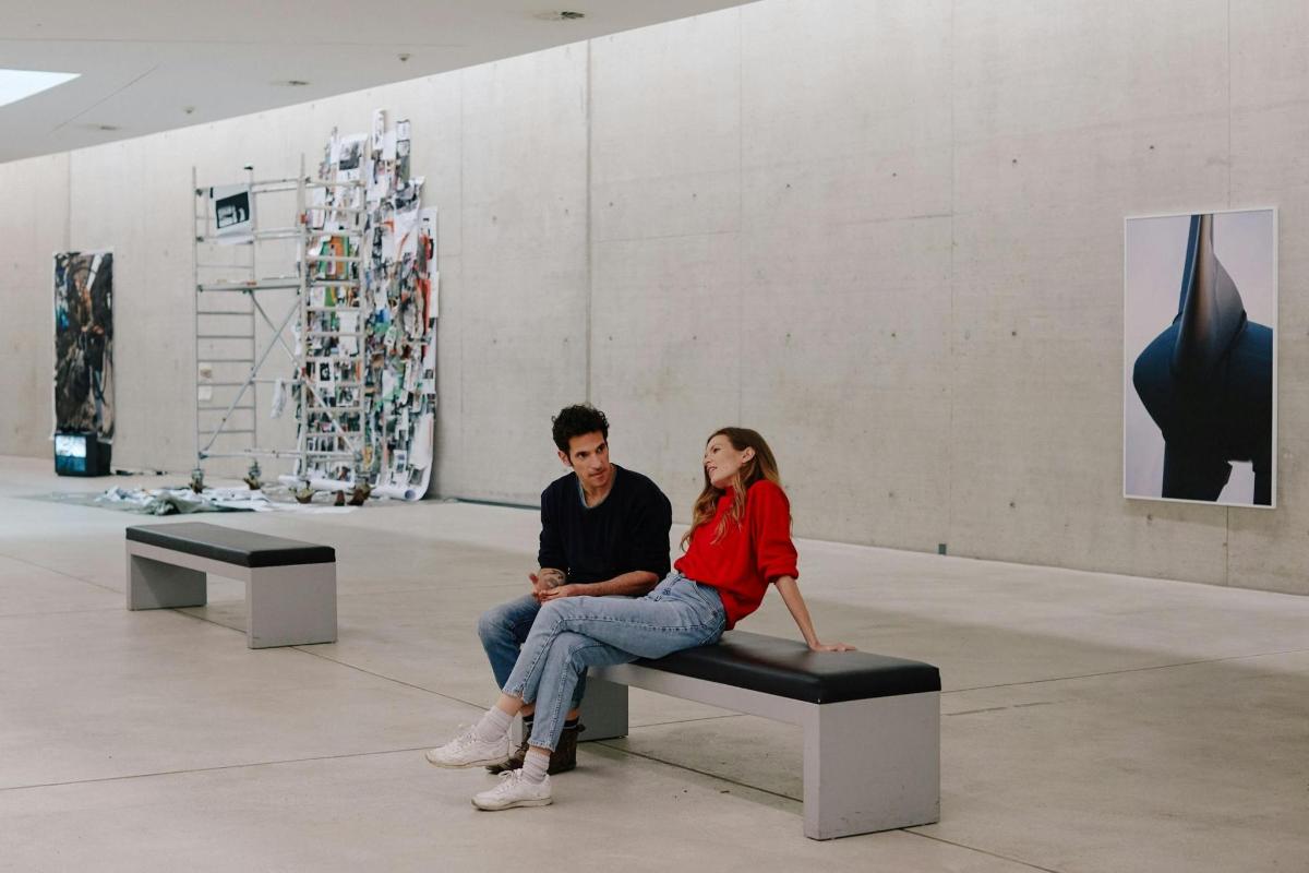 a man and a woman sitting on a bench in a room
