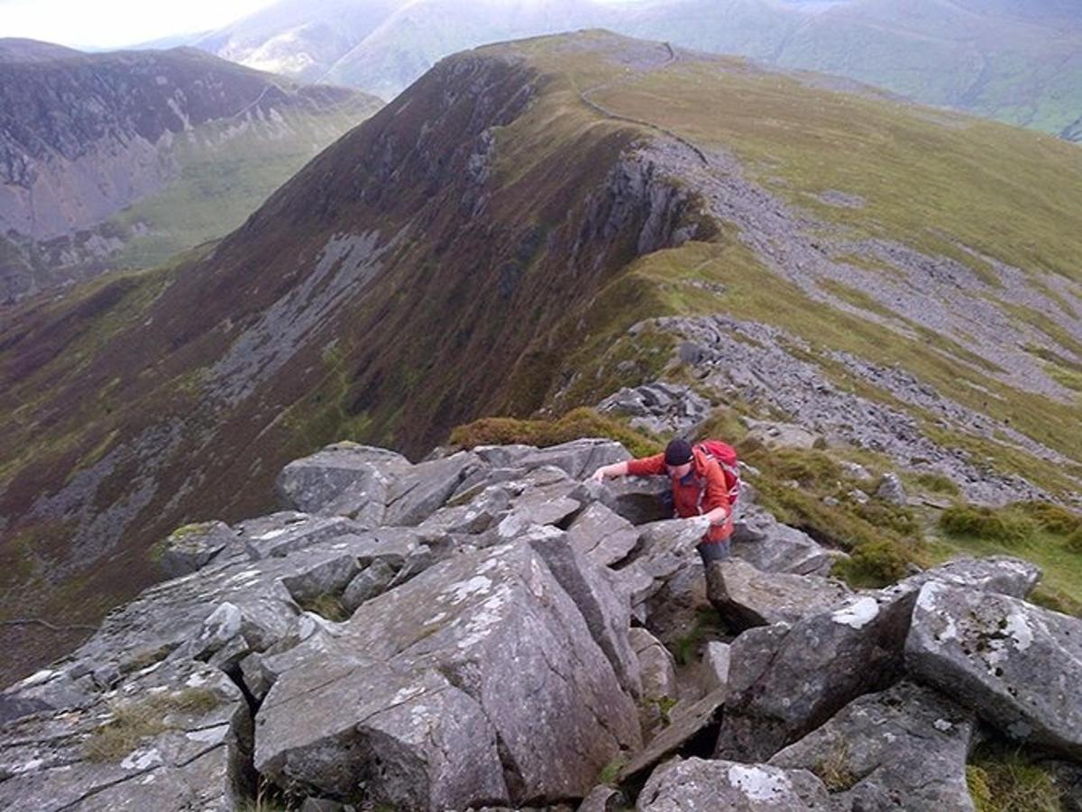 a person sitting on the edge of a mountain