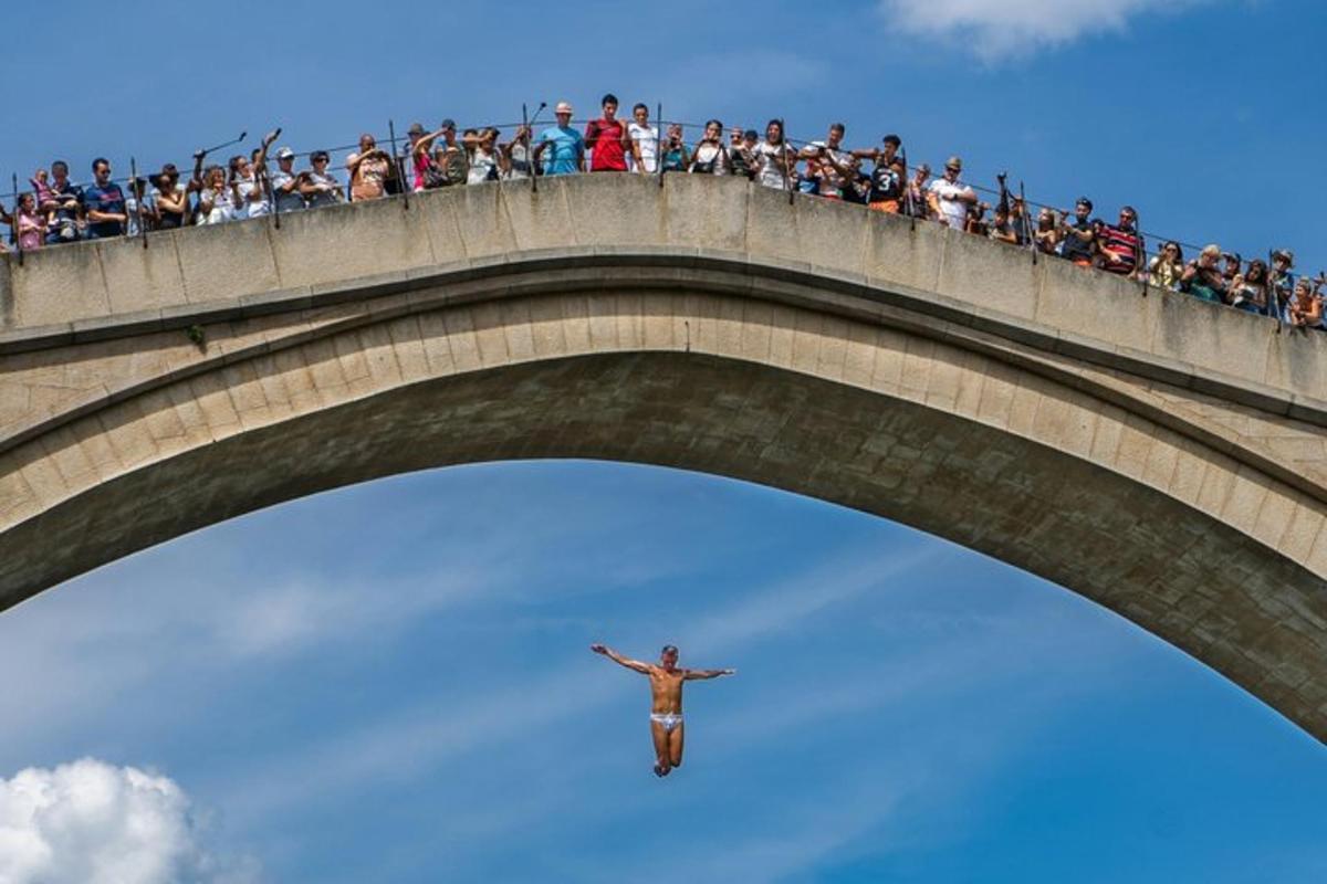 a man standing on top of a bridge with a crowd