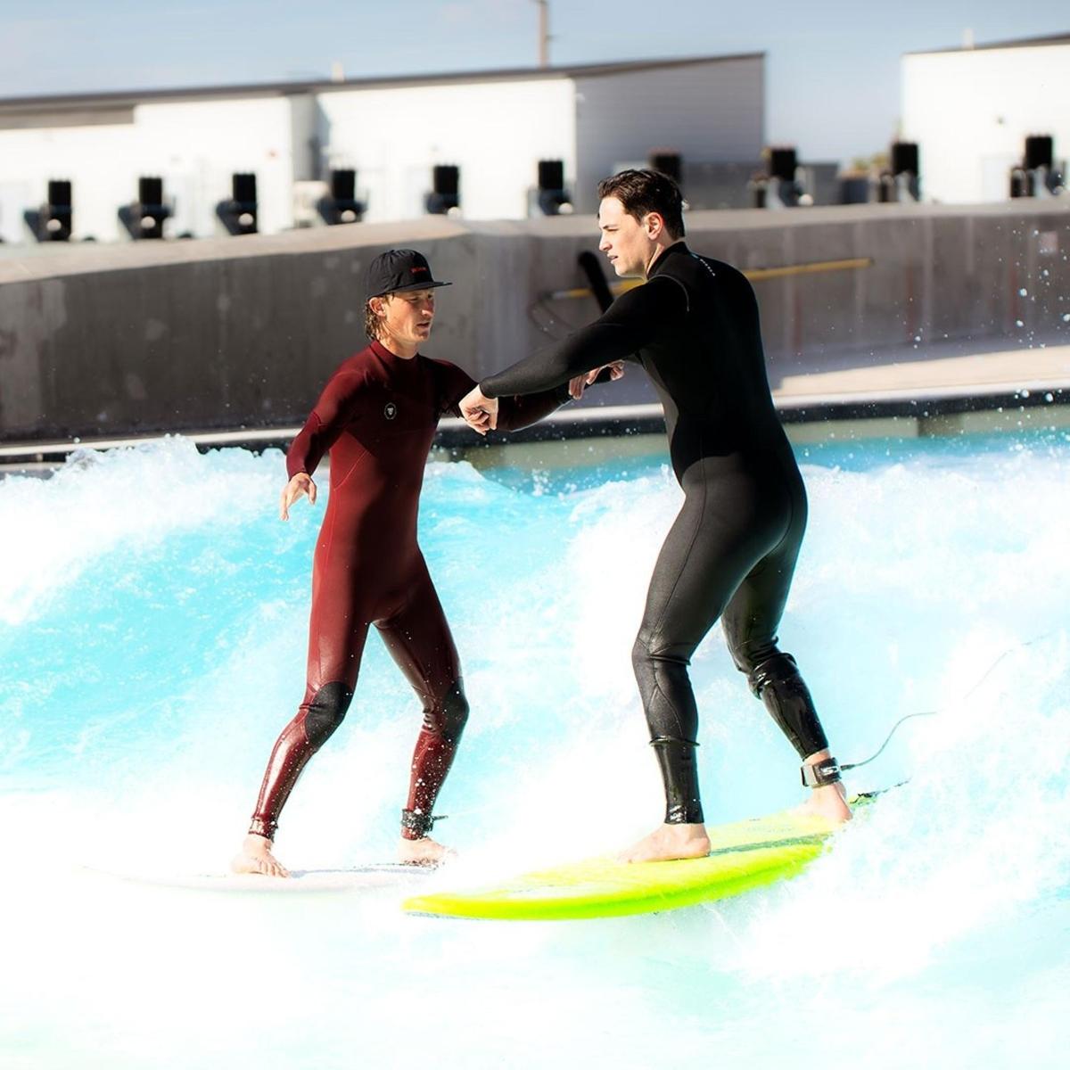 a man and a boy on surfboards in a pool