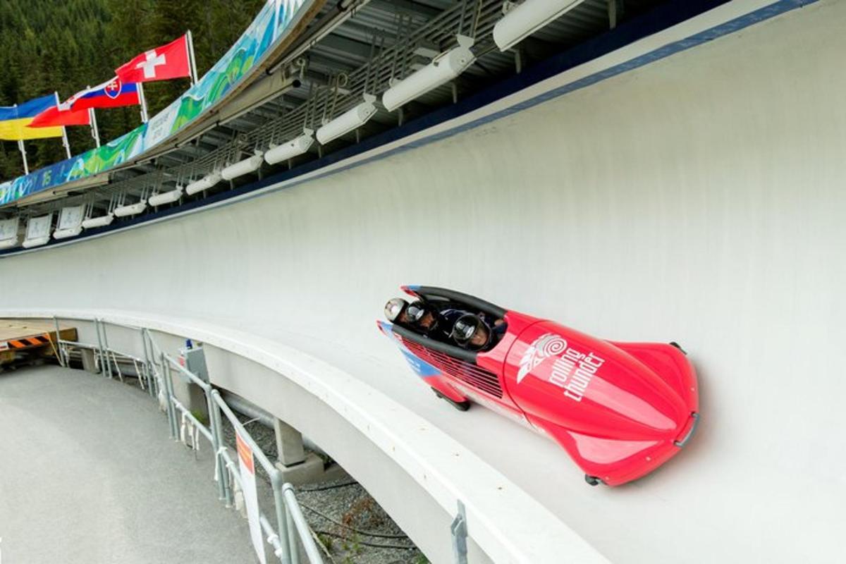 a red car on the side of a bridge