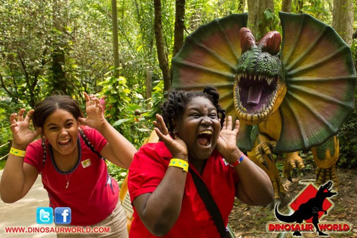 two women standing in front of a dragon costume