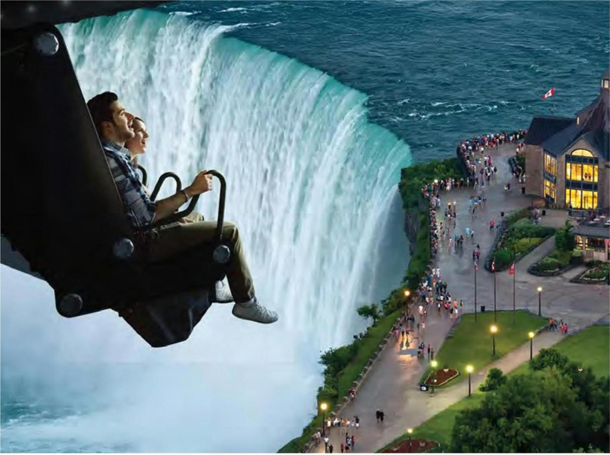 a man sitting on a chair in front of a waterfall