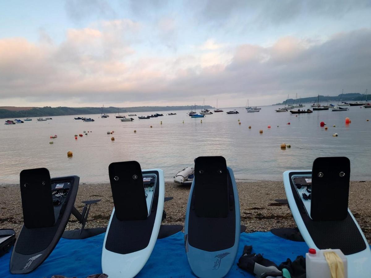 a group of four chairs sitting on the shore of a body of water