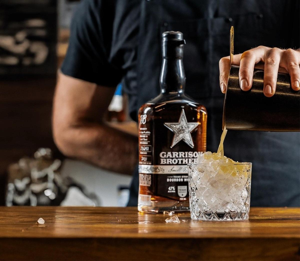 a bottle of whiskey sitting on a table with a drink