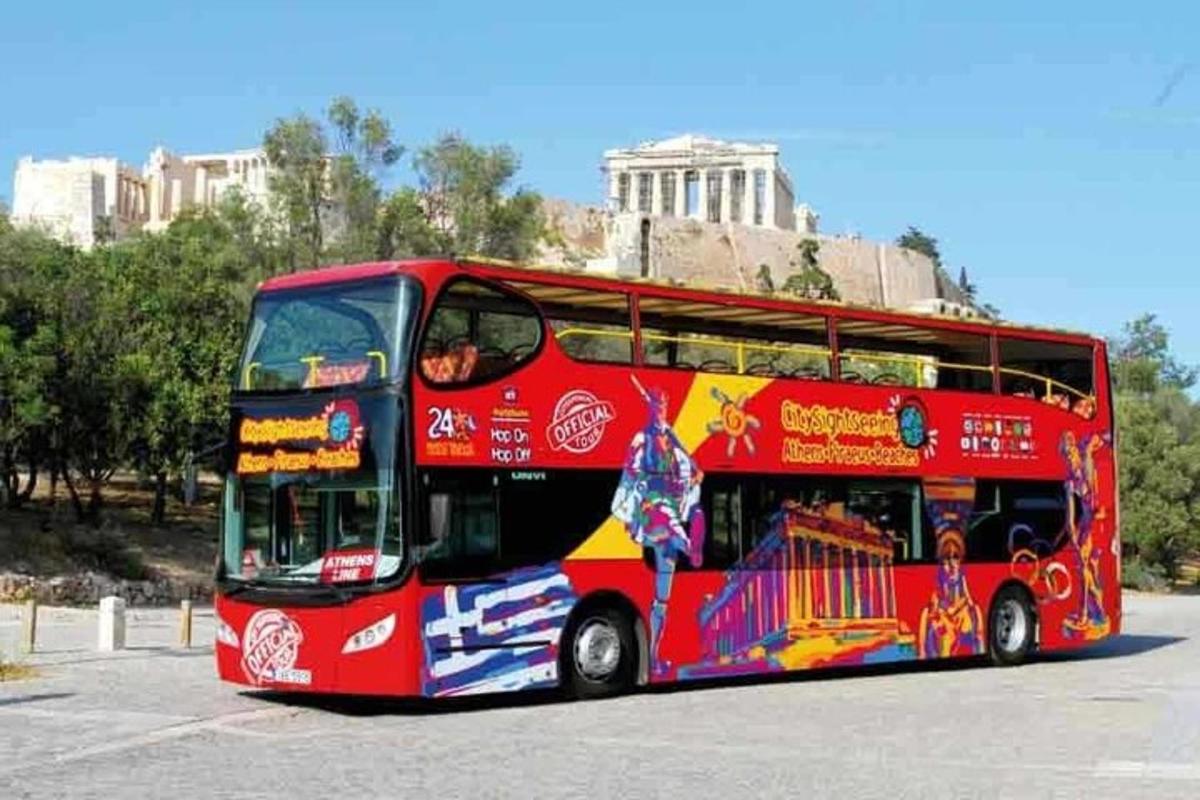 a red double decker bus parked in a parking lot