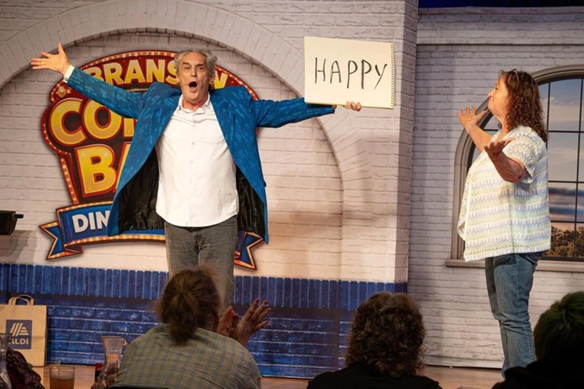 a man and a woman on a stage with a sign