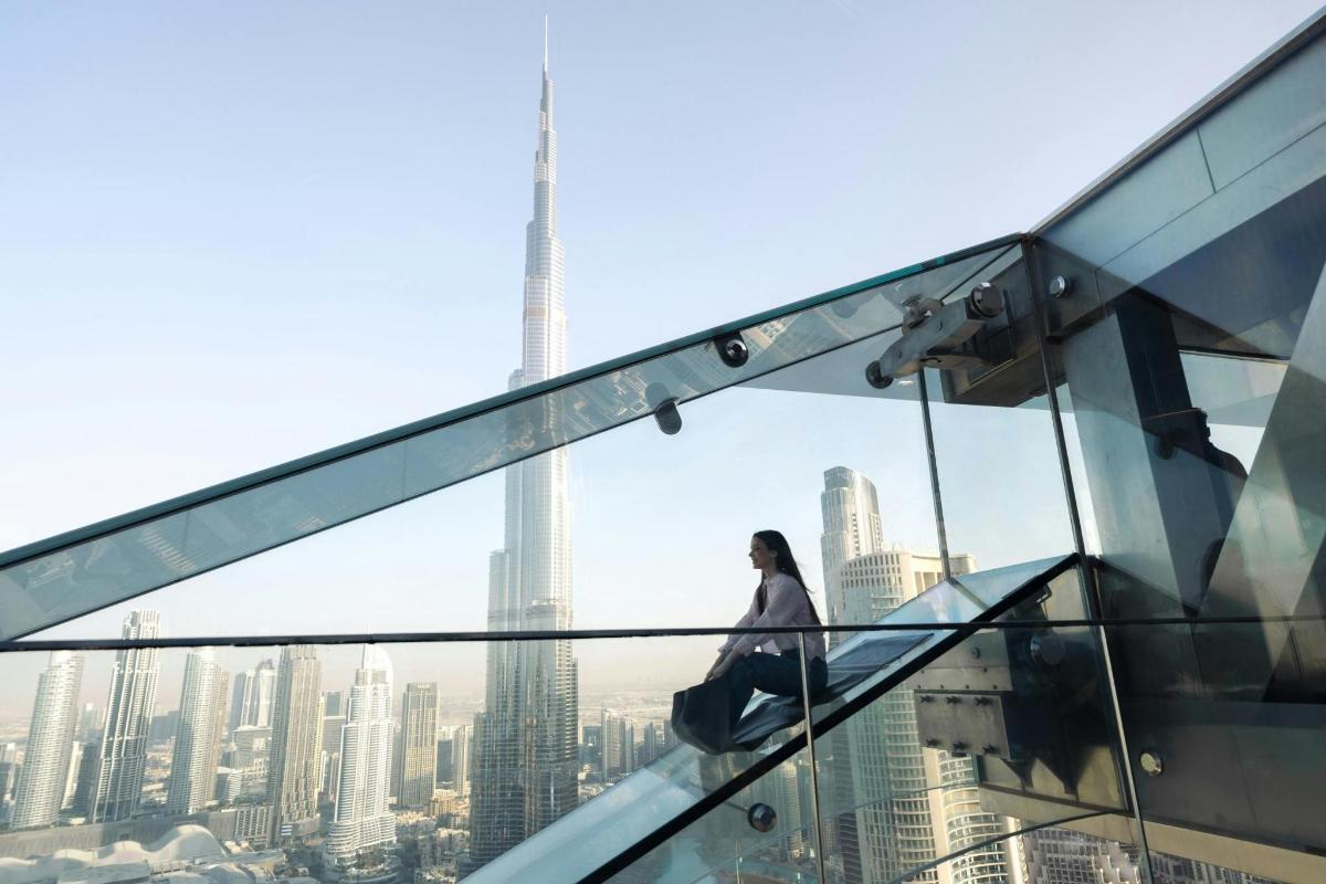 a woman standing on top of a glass building
