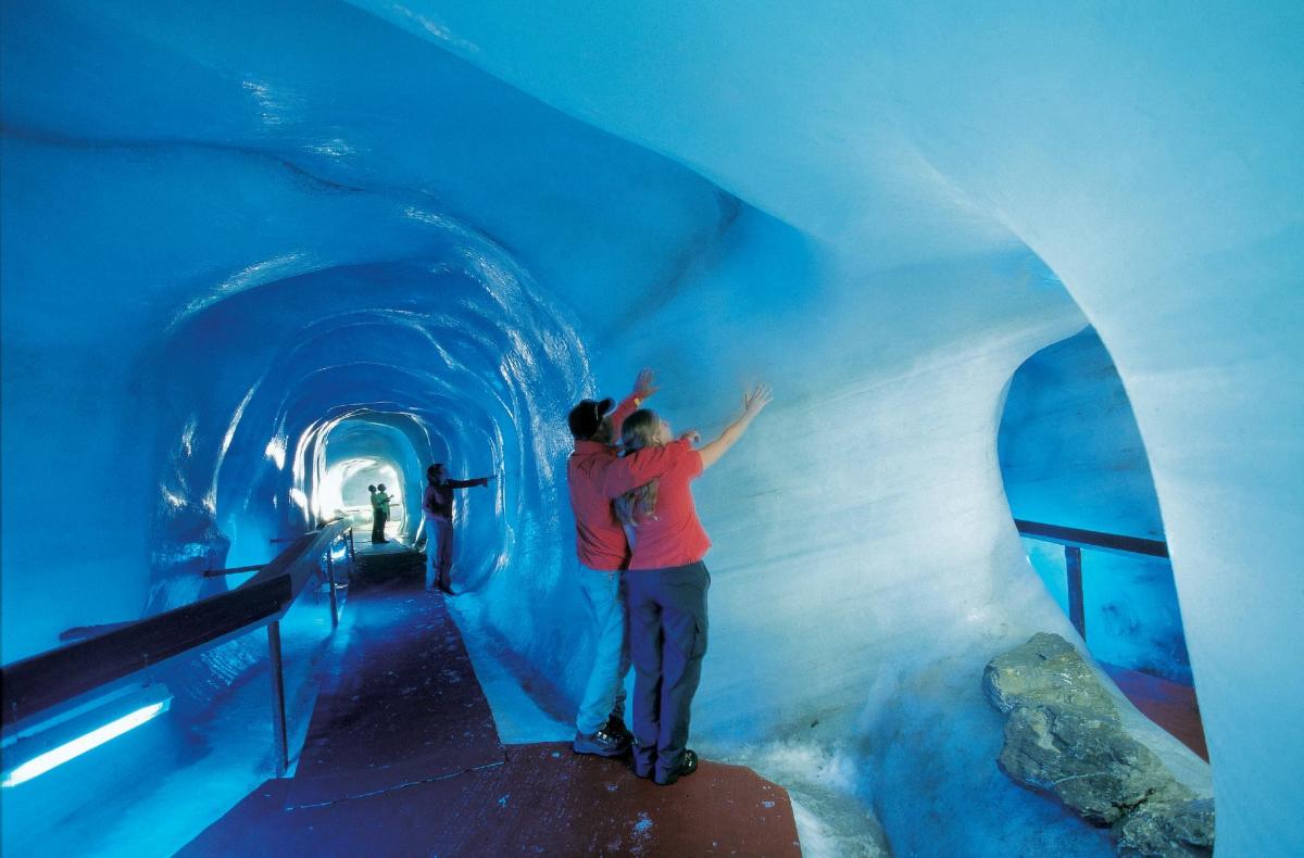 a couple of people standing in a blue tunnel