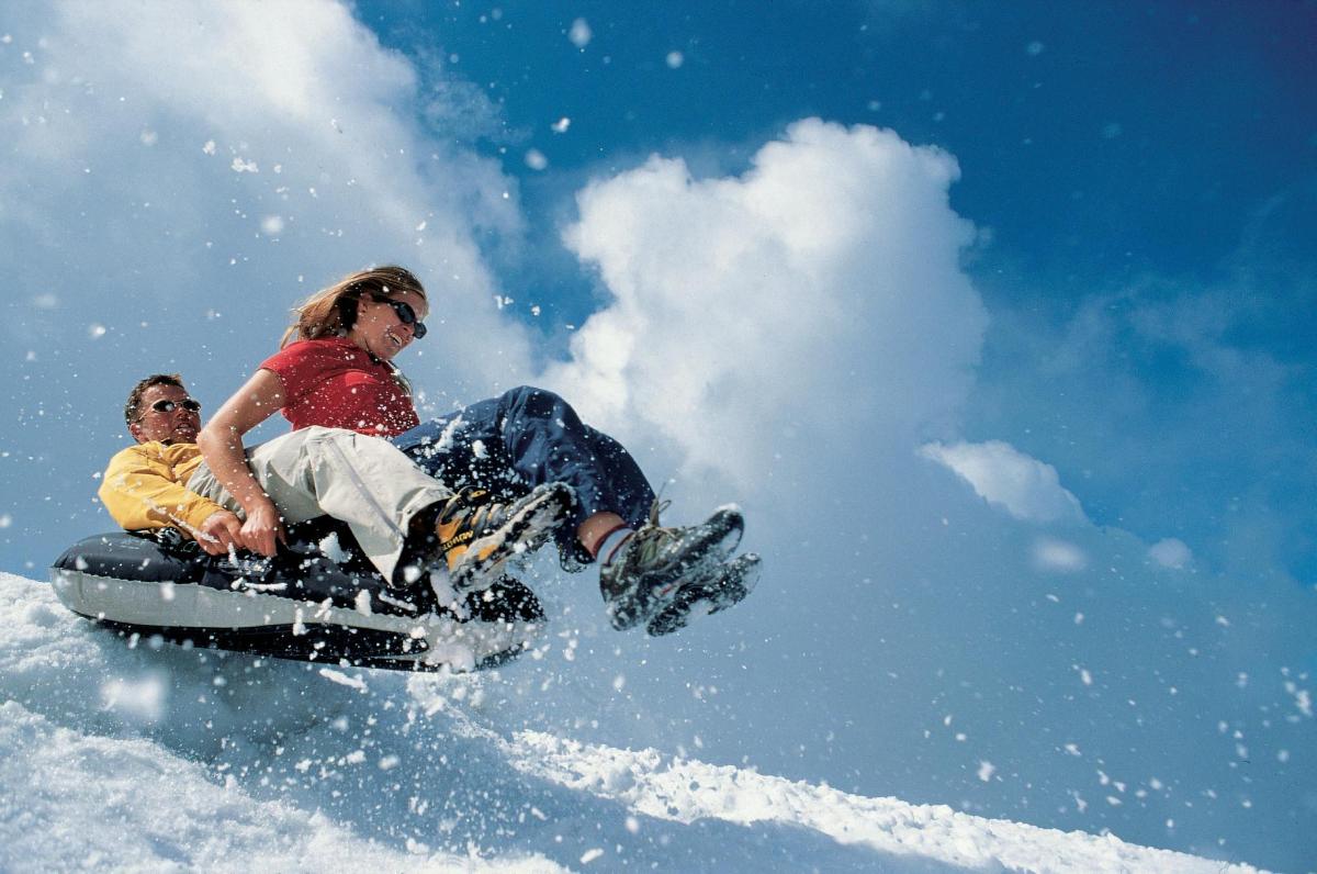 two people riding on a snowboard in the snow