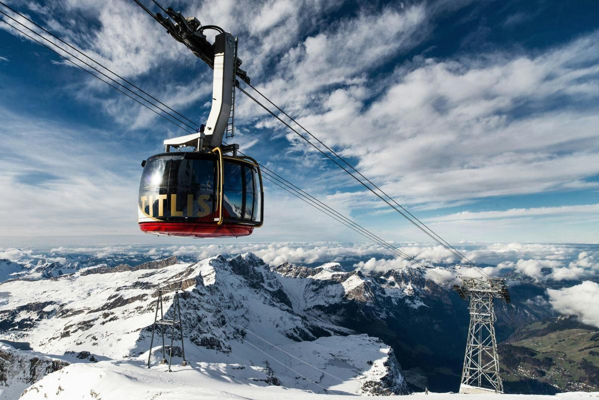 a ski lift flying over a snow covered mountain