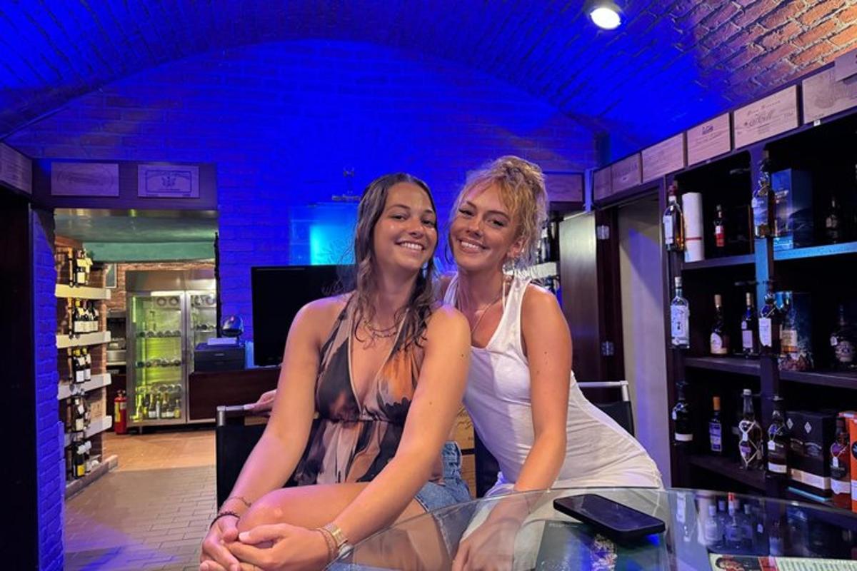 two women sitting at a counter in a bar