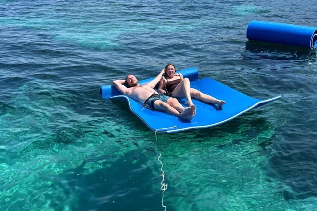 Dos personas tumbadas en una tabla de paddle surf en el agua
