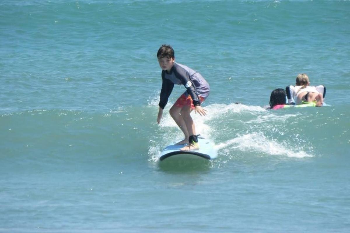 a young boy riding a wave on a surfboard in the ocean