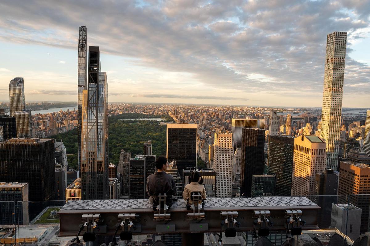 a man sitting on a chair looking at a city skyline