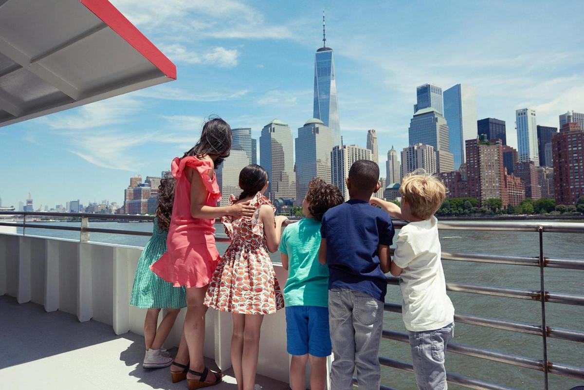 a group of children standing on a bridge looking at a city