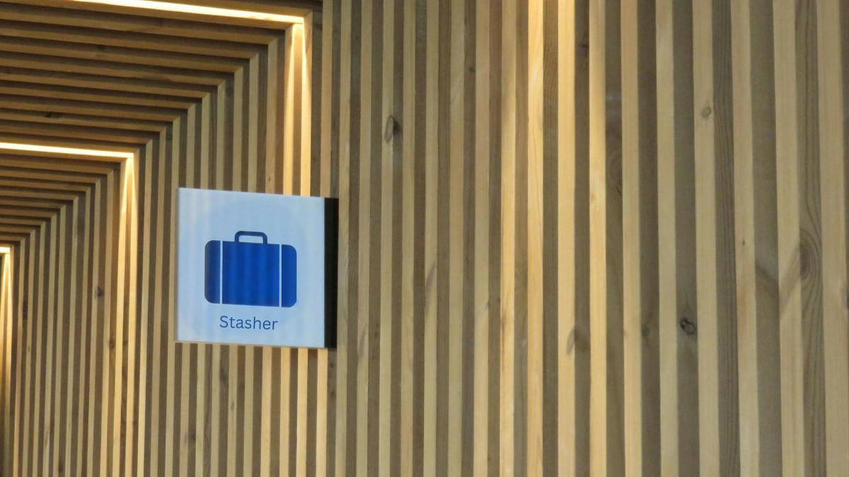 a sign on a wall with a suitcase on it