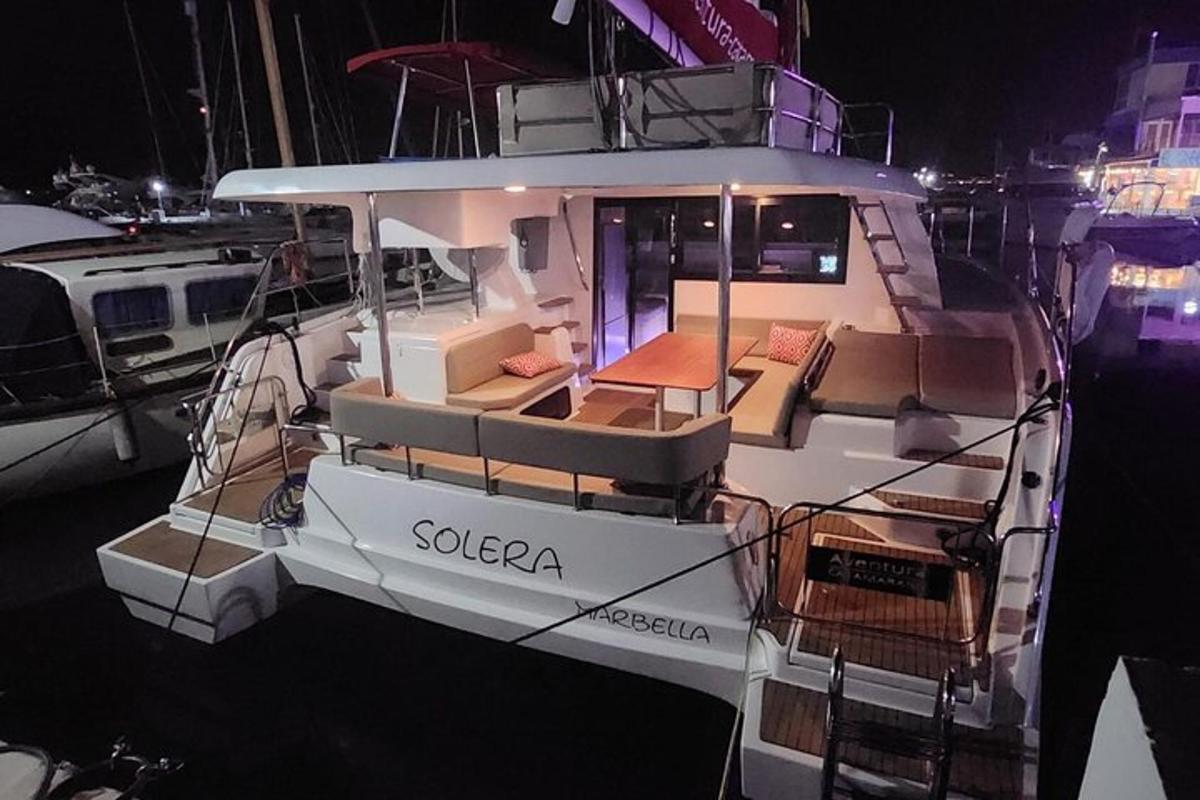 a white boat sitting in the water at night