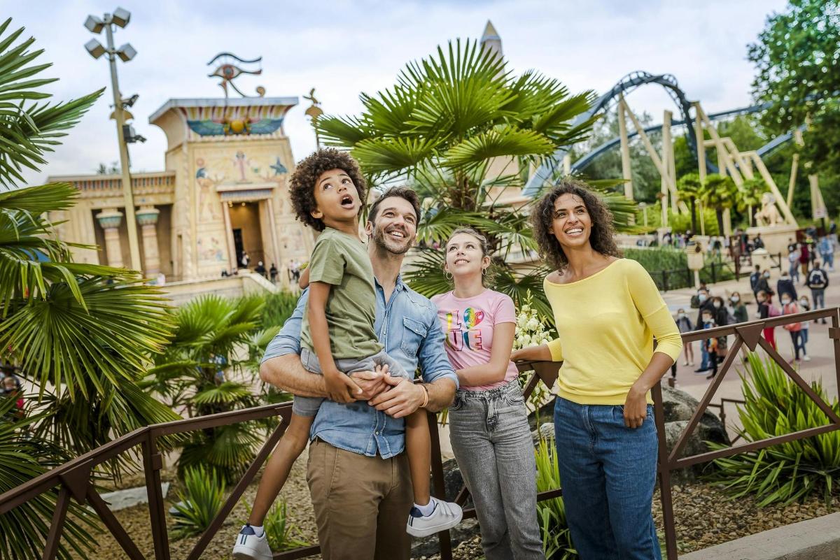 a family posing in front of a amusement park