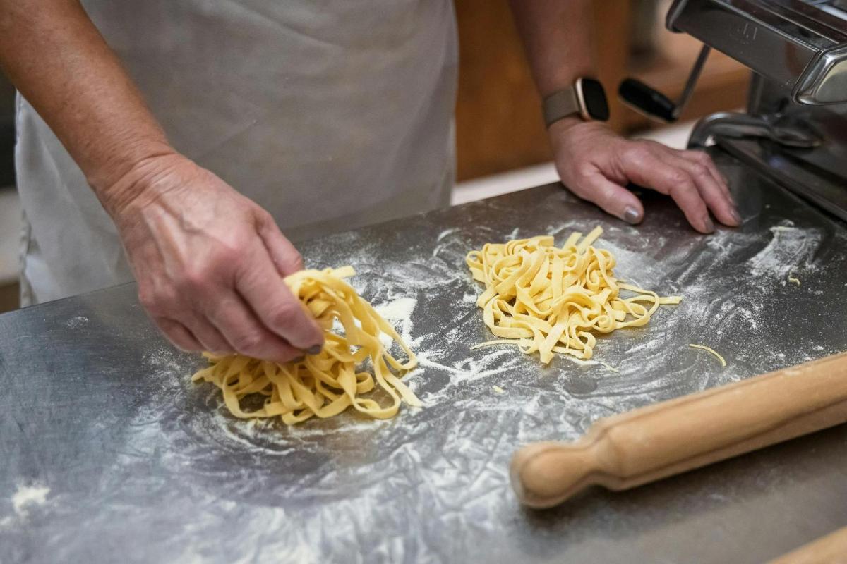 a man is preparing pasta on a counter