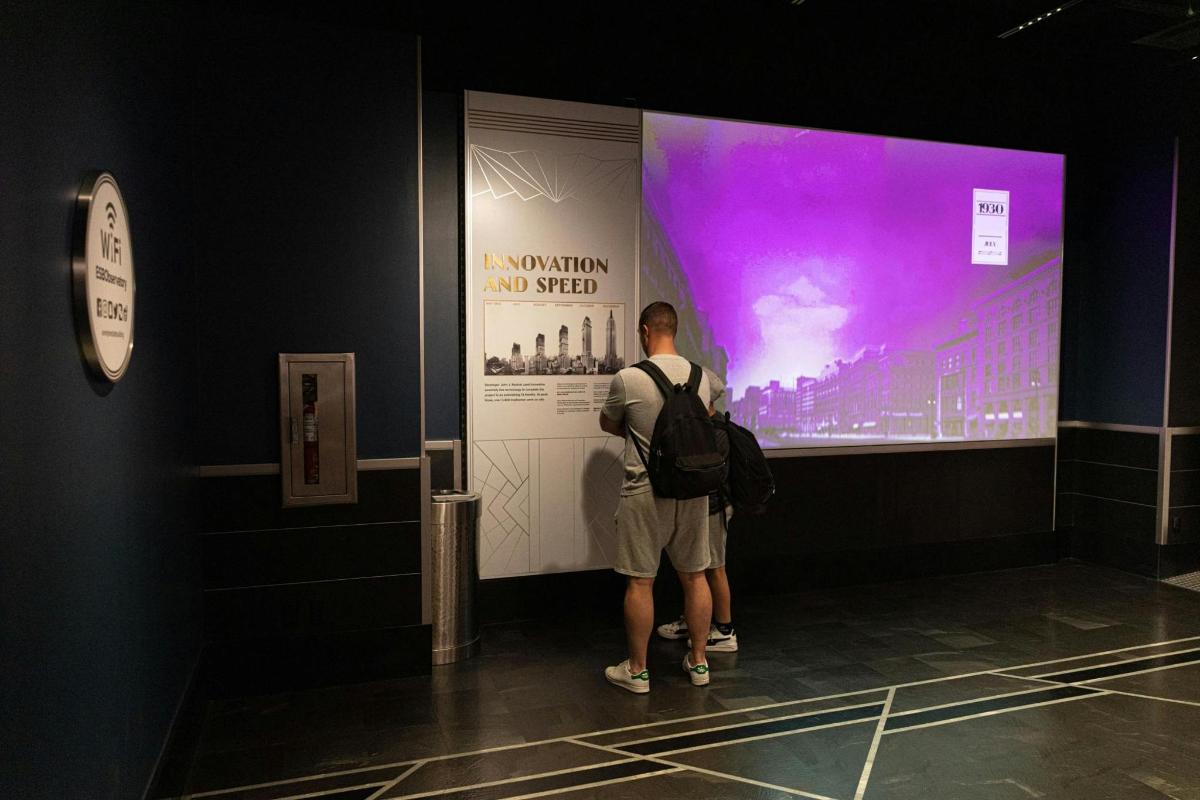 a man standing in front of a large screen