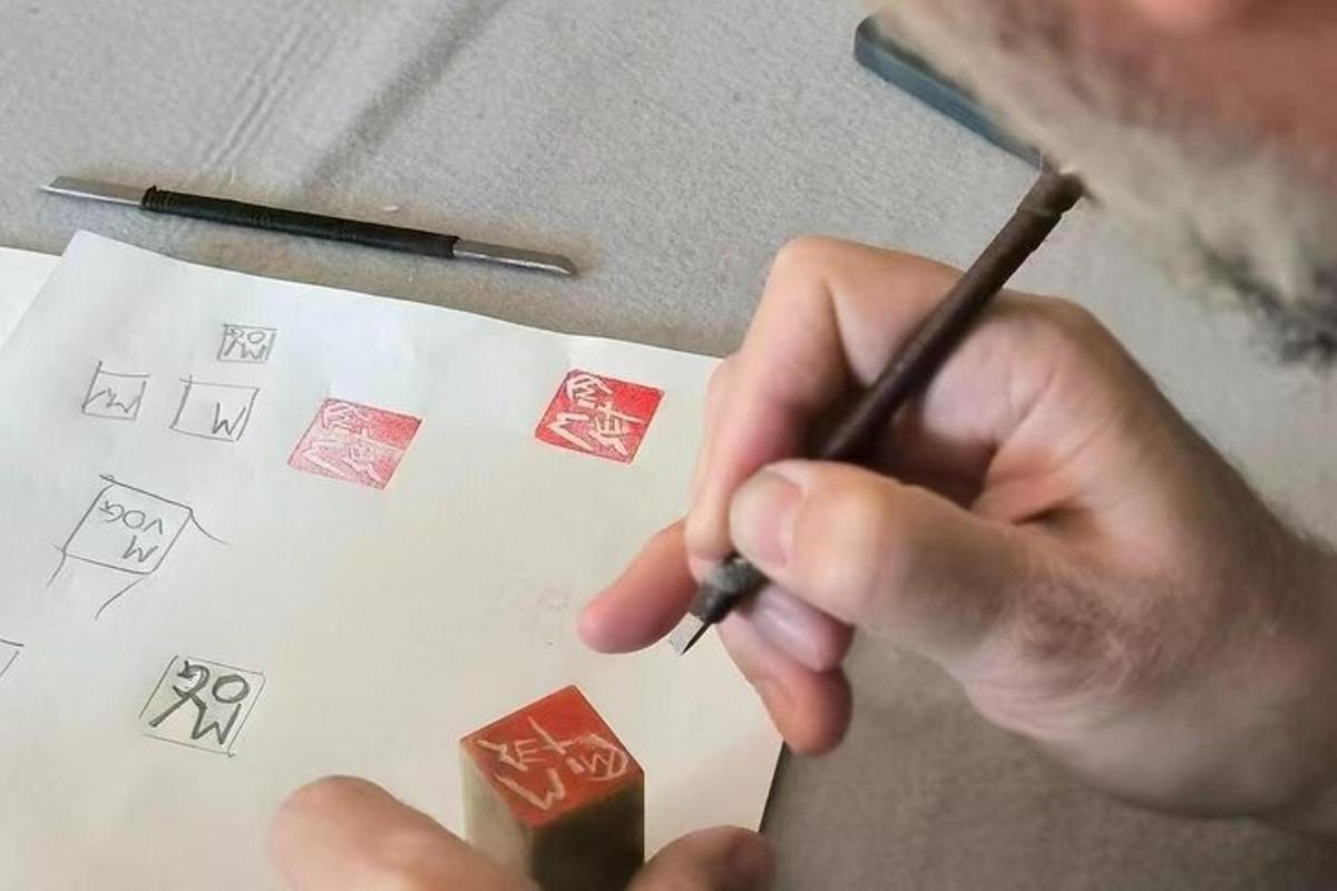 a man holding a pencil and writing on a piece of paper