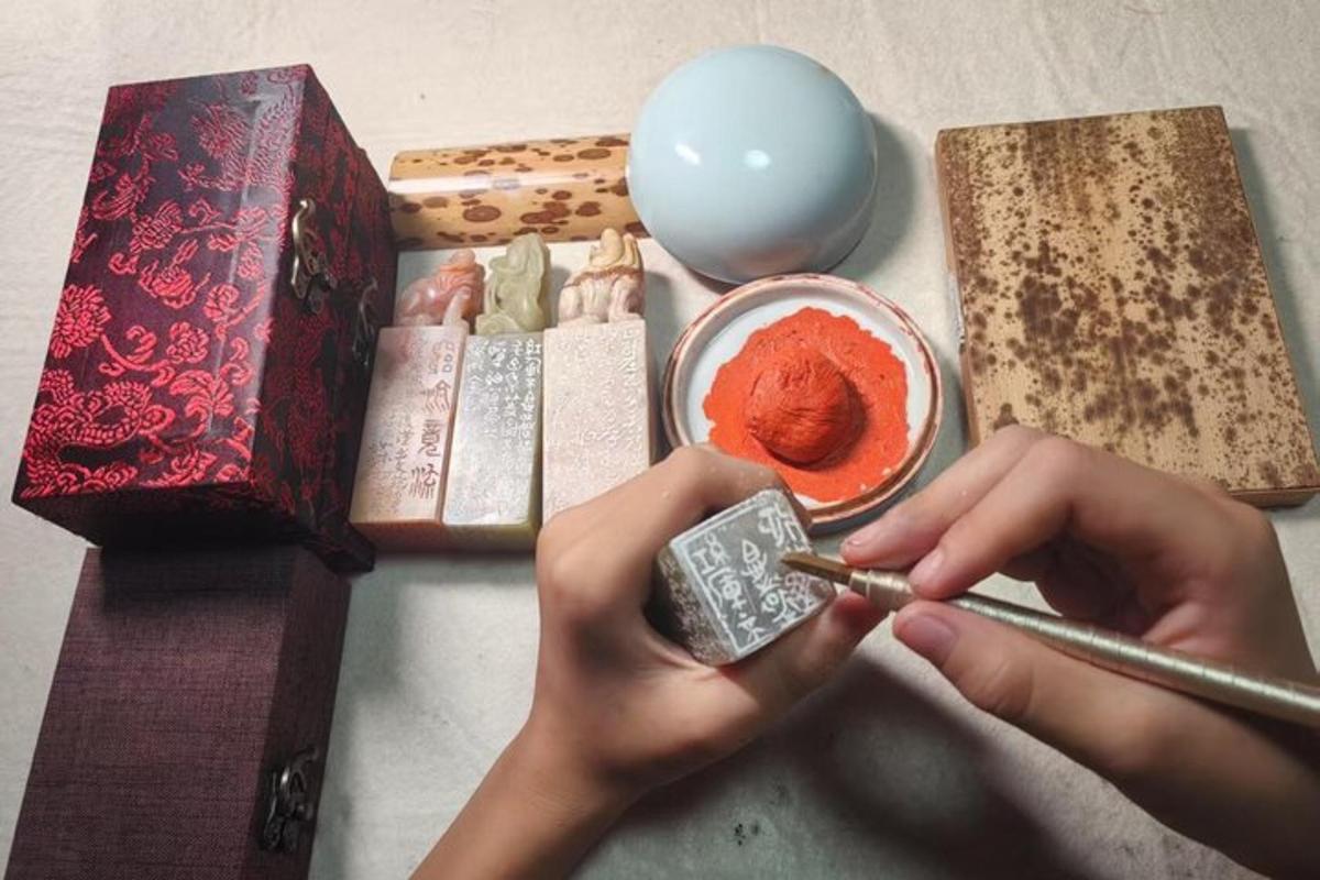 a person holding a cell phone next to a bowl of red paint
