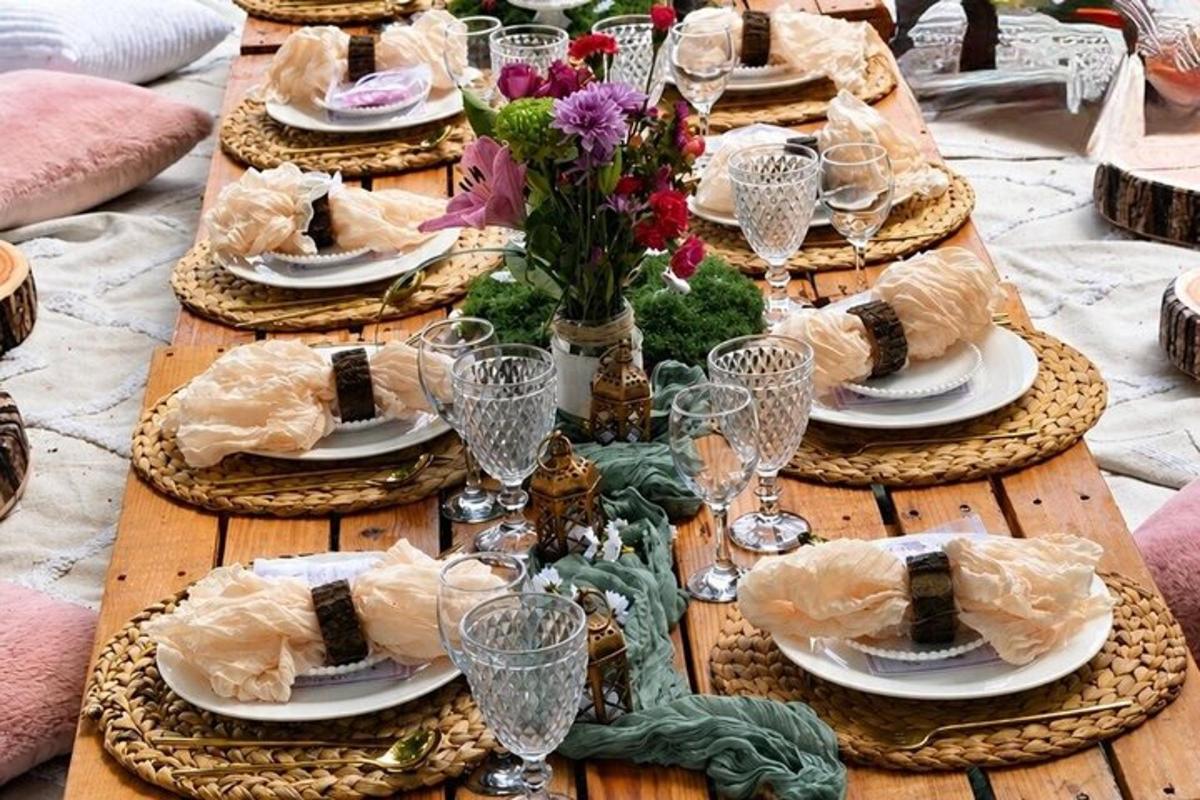 a wooden table with plates of food and wine glasses