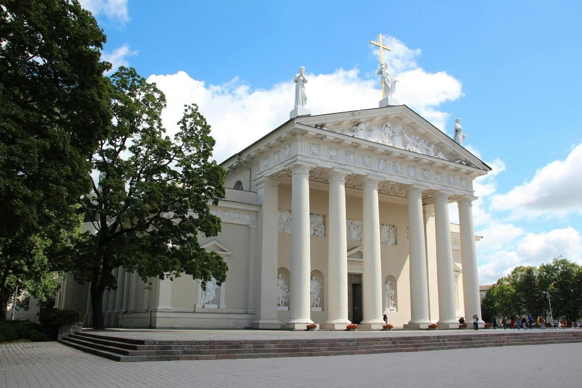 a white building with columns and a cross on top