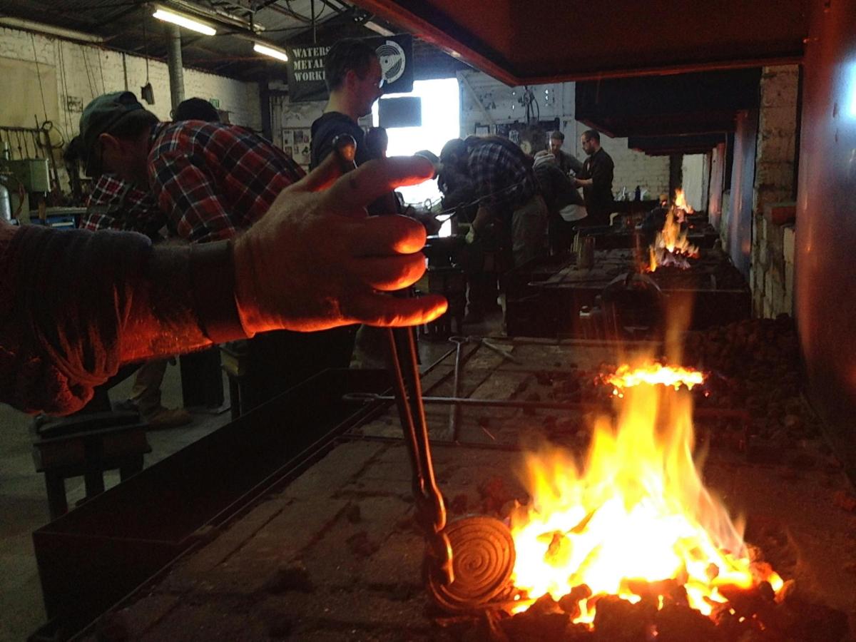 a person is holding a pole over a fire