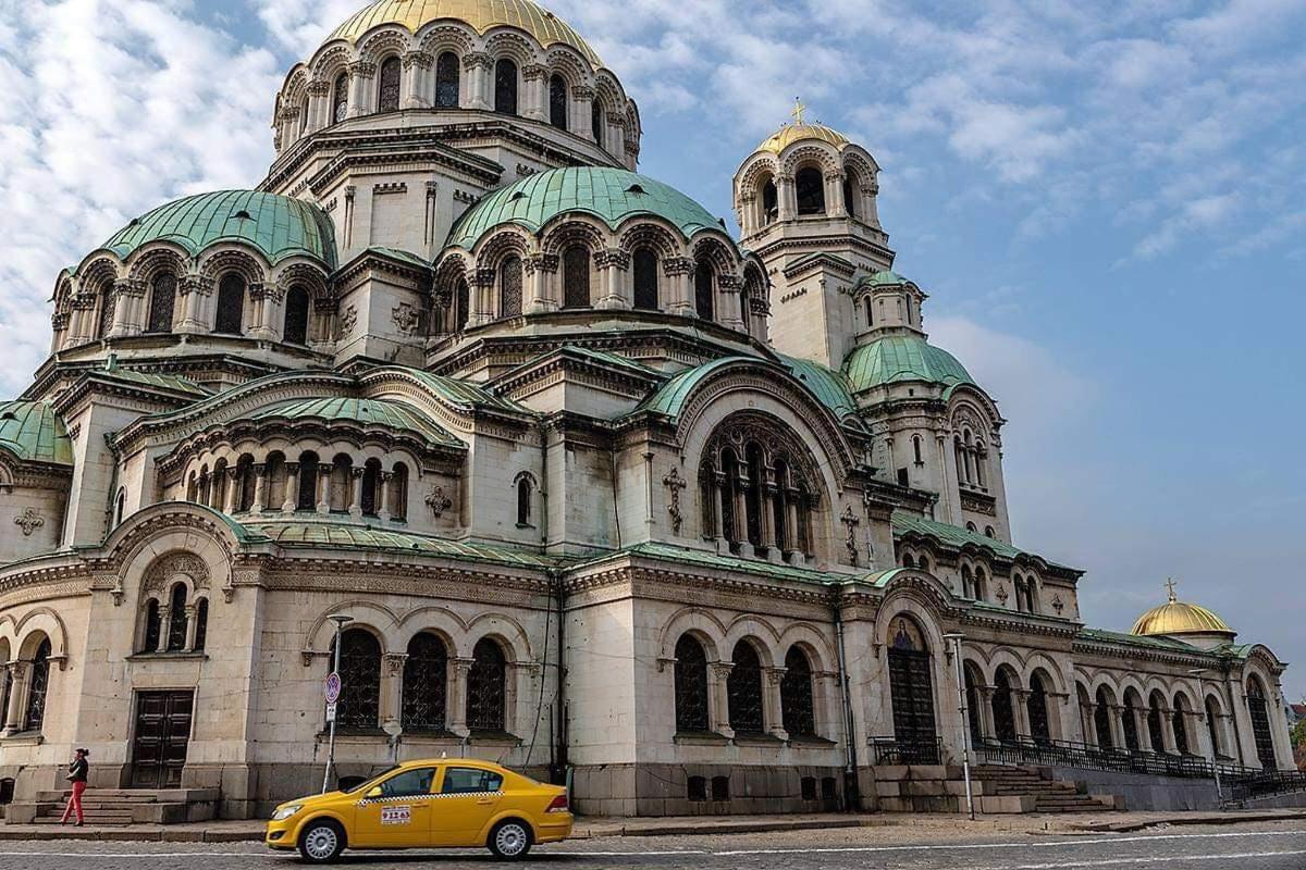 a yellow car parked in front of a large building
