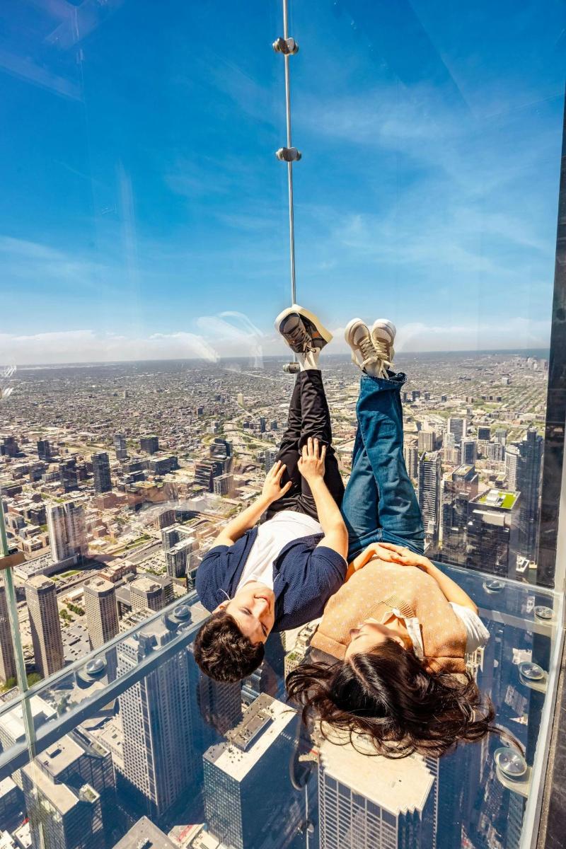 a group of people hanging from the top of a skyscraper