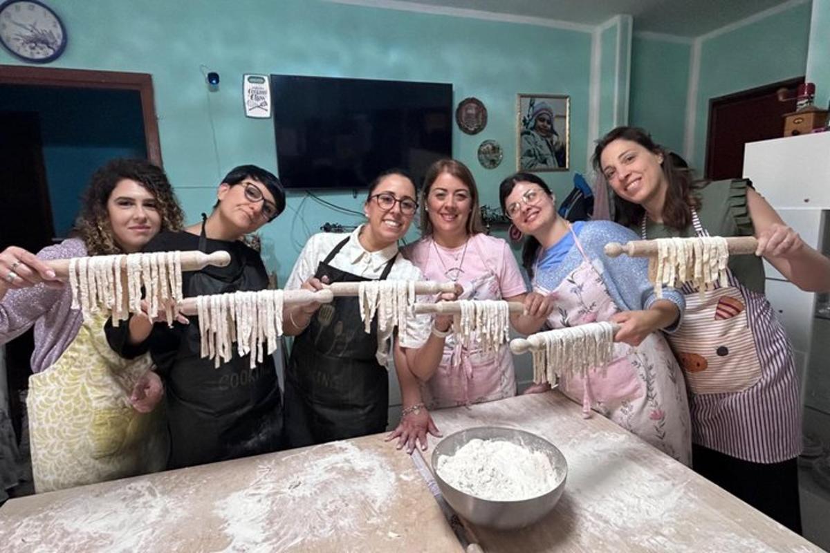 a group of women standing around a table with dough