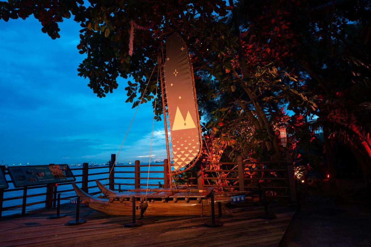 a wooden boat with a sail sitting on a deck