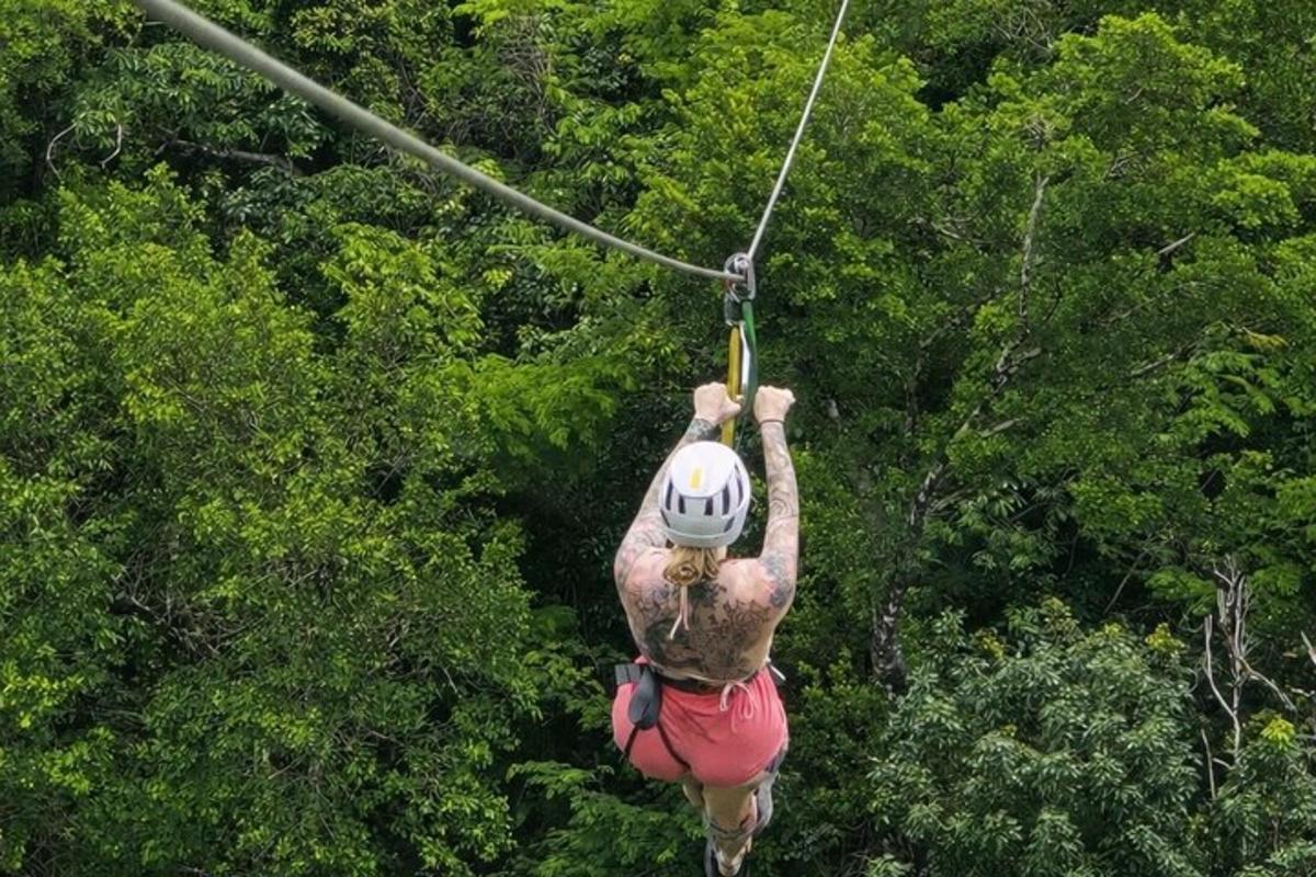 a person on a zip line in front of trees