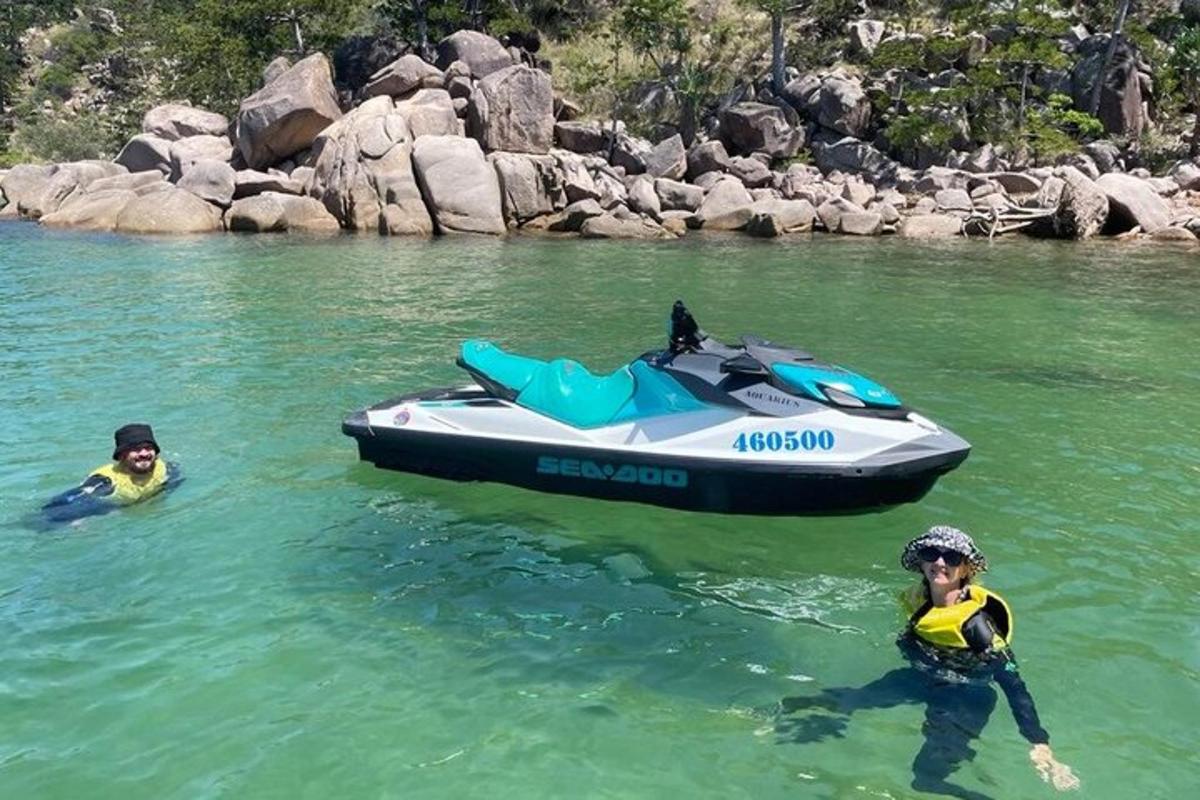 two people in the water next to a speed boat