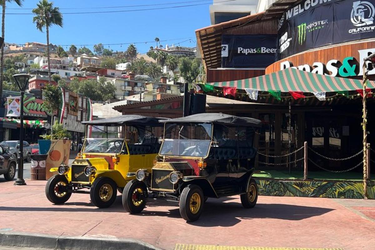 two old cars are driving down a street