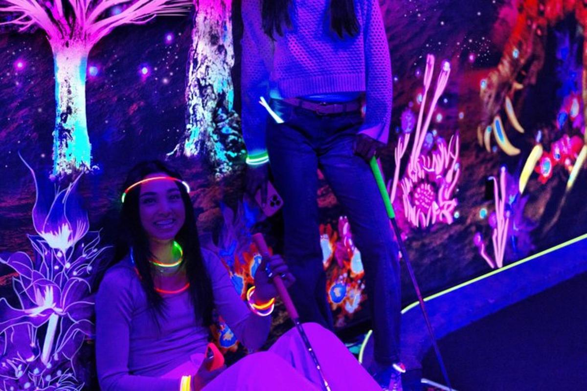 two girls sitting in front of a wall with lights