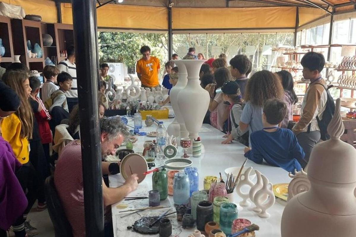 a group of people standing around a table with vases
