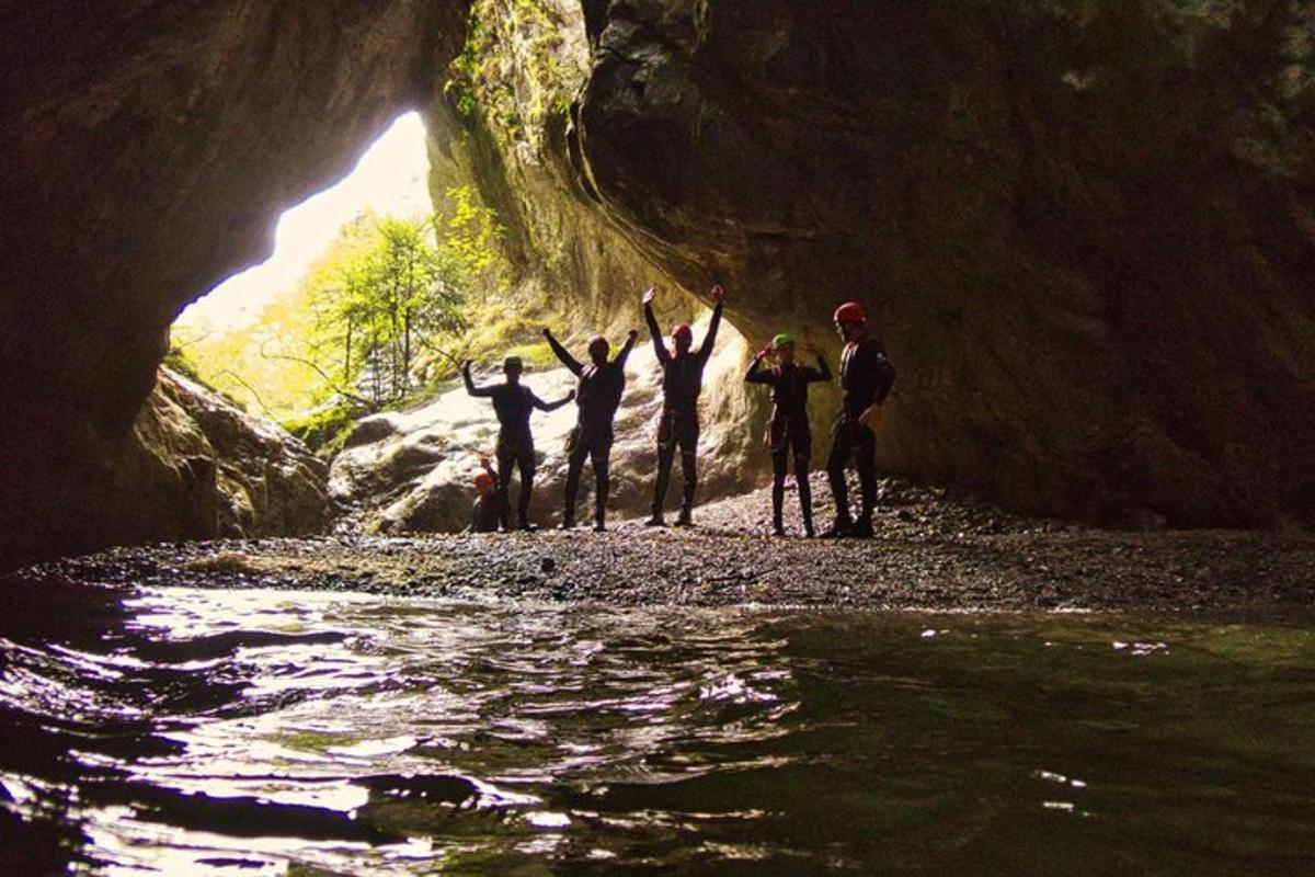 a group of people standing in a cave next to a river