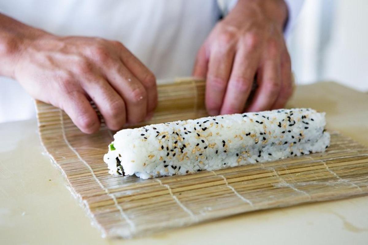 a person is preparing sushi on a cutting board
