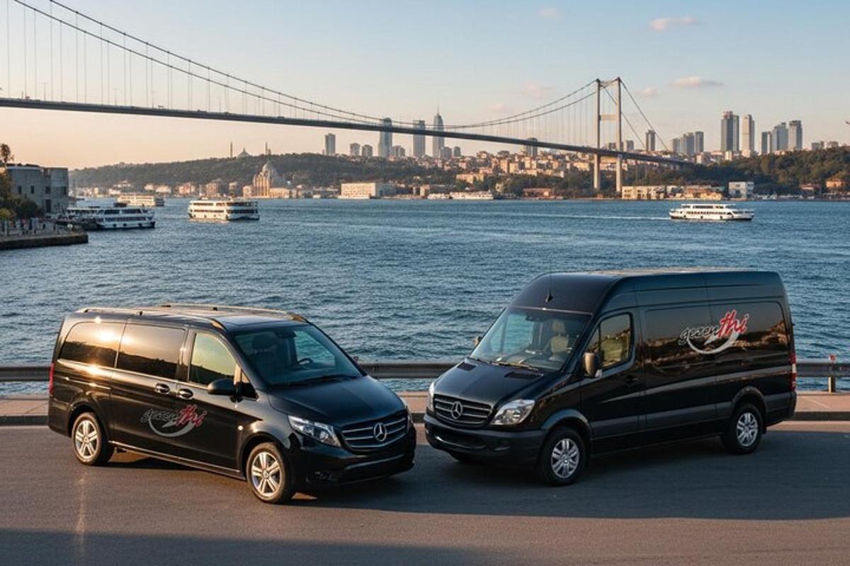 two black vans parked next to a river with a bridge
