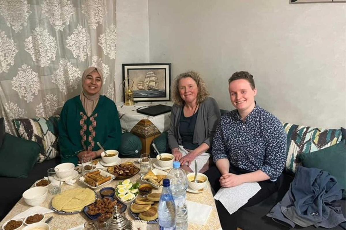 a group of people sitting around a table with food