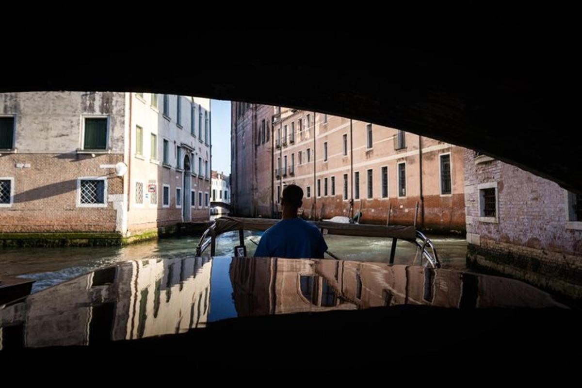 a man riding a boat down a canal