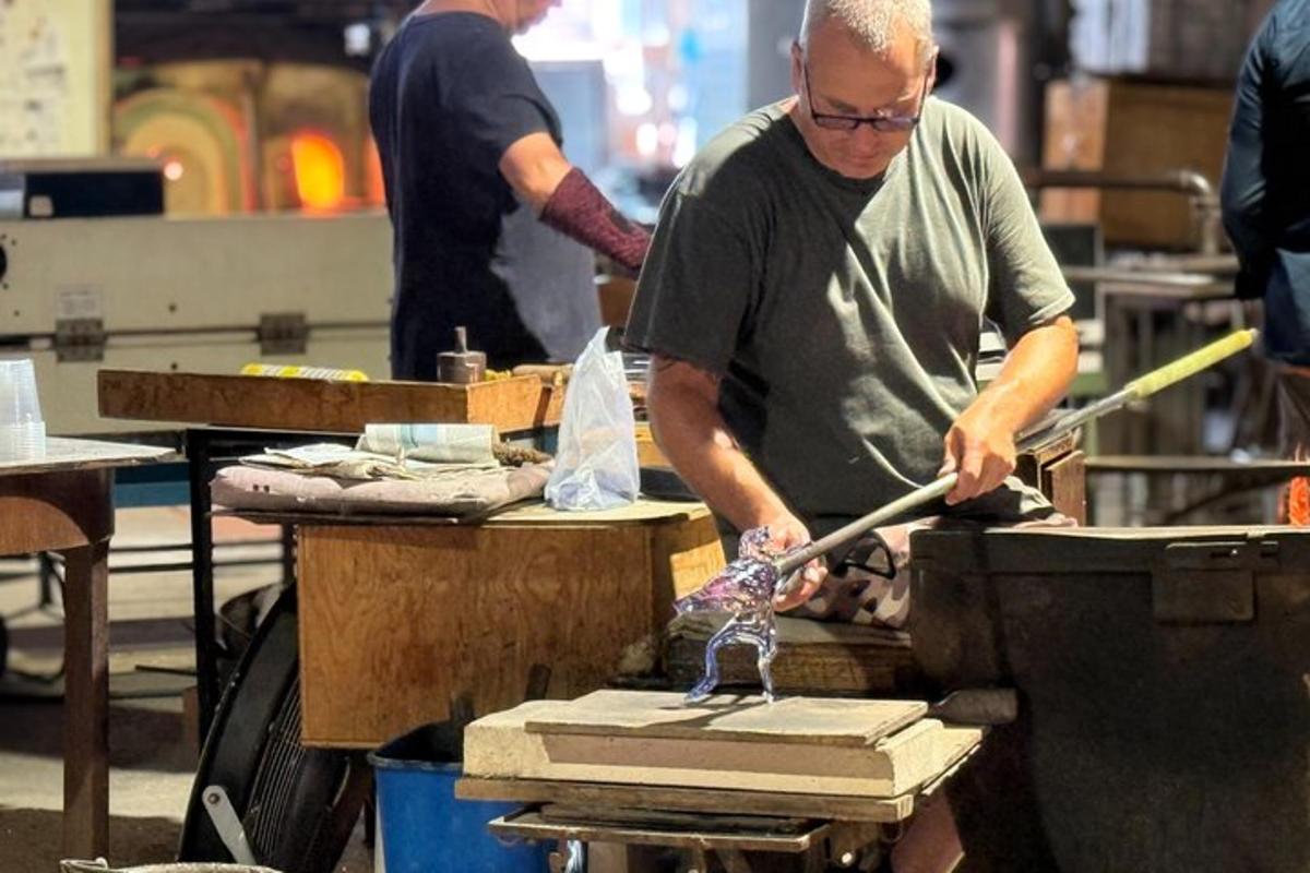a man ironing a piece of wood on a table