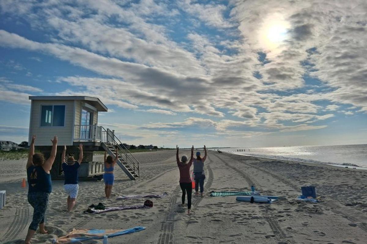 a group of people standing on a beach with their hands up