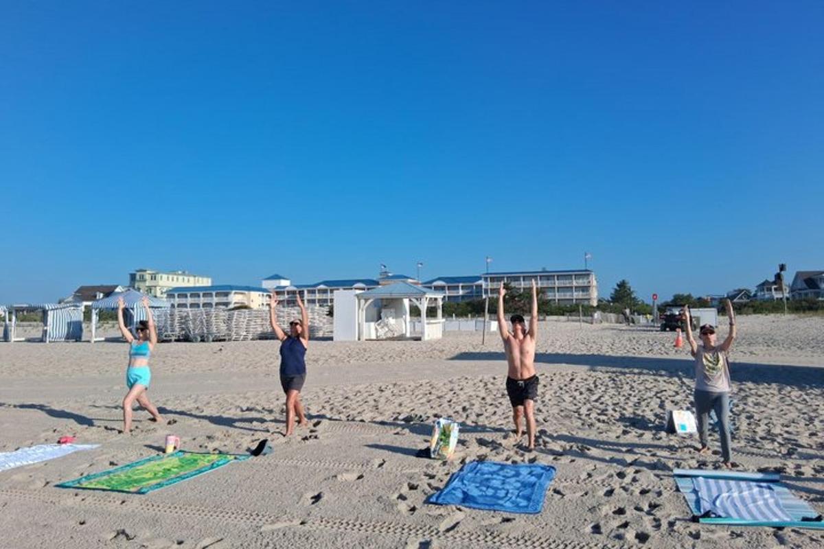 a group of people doing yoga on the beach