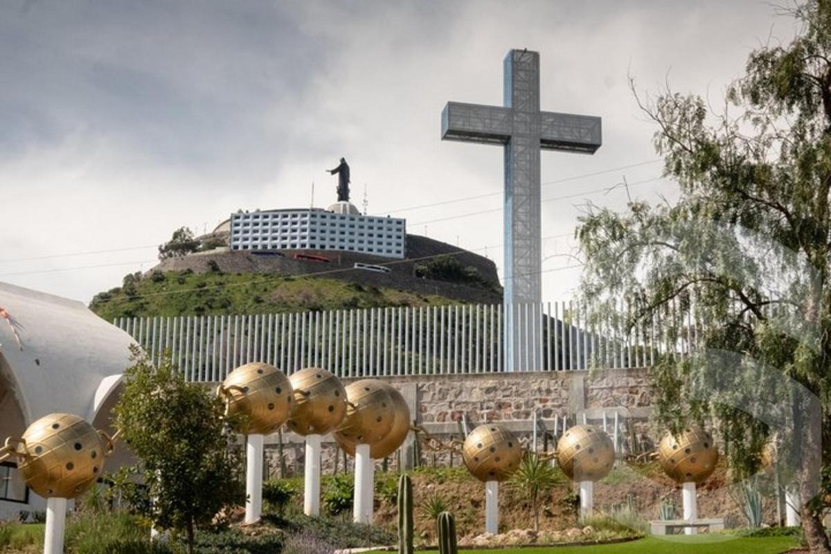 a cross and golden balls in front of a church