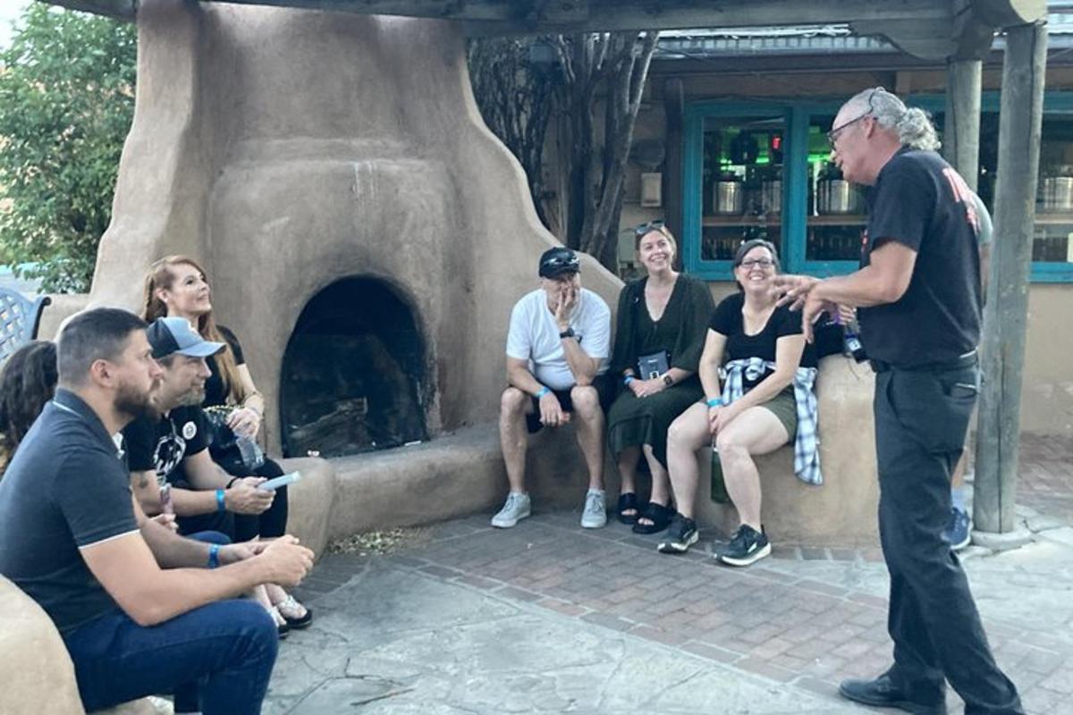 a man talking to a group of people in front of an oven